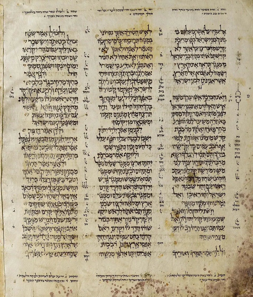 A parchment page of the Aleppo Codex in three columns of pointed Hebrew script with marginal notes