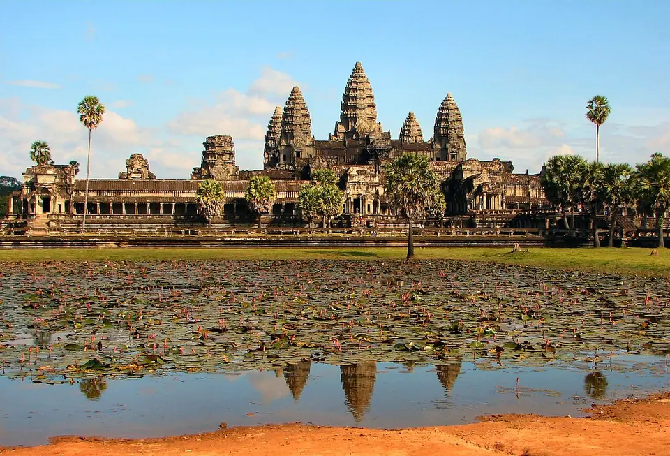 Angkor Wat's five towers seen across a lotus pond, reflected in the water