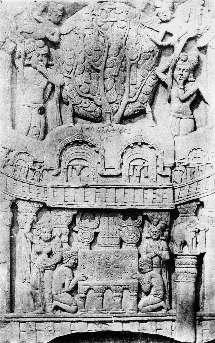 Bharhut relief of a pipal tree rising above a two-storeyed pillared shrine, with worshippers kneeling at an empty seat beneath it and a short Brāhmī label above