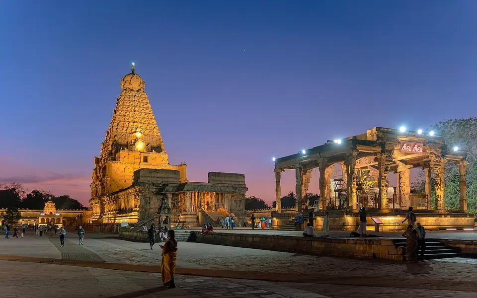 The Brihadisvara temple at Thanjavur illuminated at dusk during Maha Shivaratri, its tall pyramidal tower rising above the courtyard