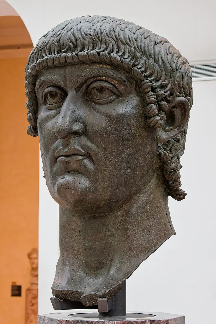 A colossal bronze head of a fourth-century emperor with large upturned eyes and a cap of curls, usually identified as Constantine, in the Capitoline Museums, Rome