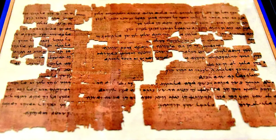 A long brown papyrus sheet with columns of Aramaic writing in black ink, from Elephantine, in a museum case