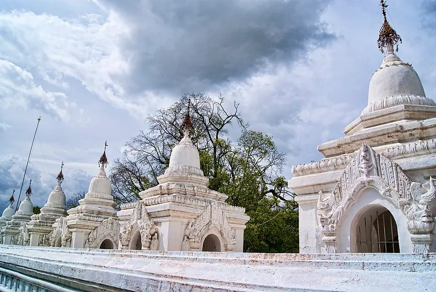 Rows of small white shrines with spired roofs at the Kuthodaw Pagoda in Mandalay, each housing a marble slab of the Pali canon