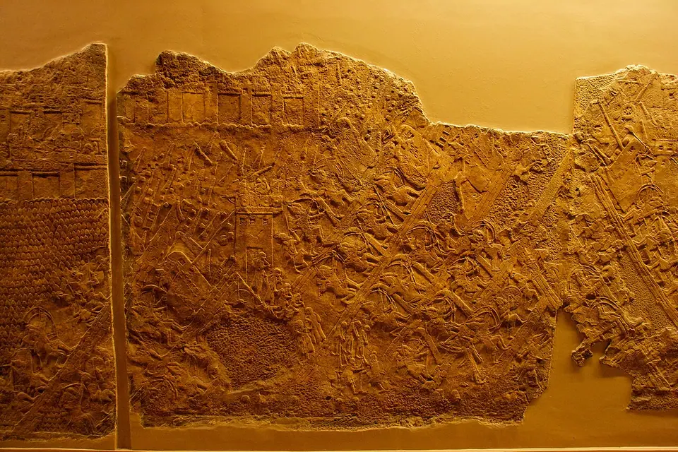 A carved Assyrian wall relief from Sennacherib's palace at Nineveh showing the siege of the Judahite city of Lachish, with towers, siege ramps and attacking soldiers