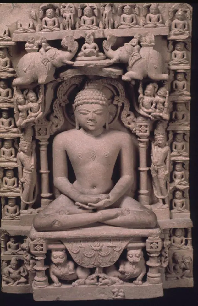 Stone relief of Mahavira seated in meditation, framed by smaller carved seated Jain figures