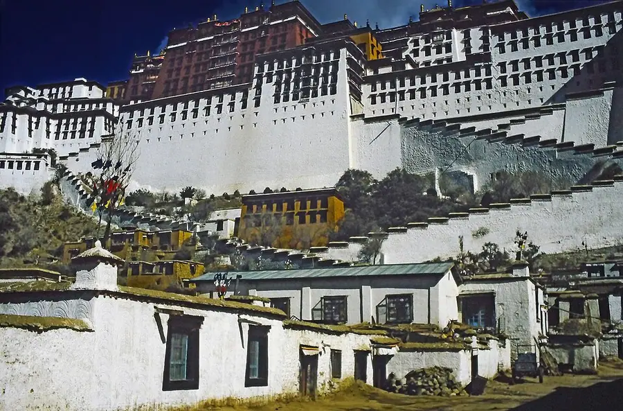 The white and red walls of the Potala Palace rising in tiers above whitewashed houses in Lhasa
