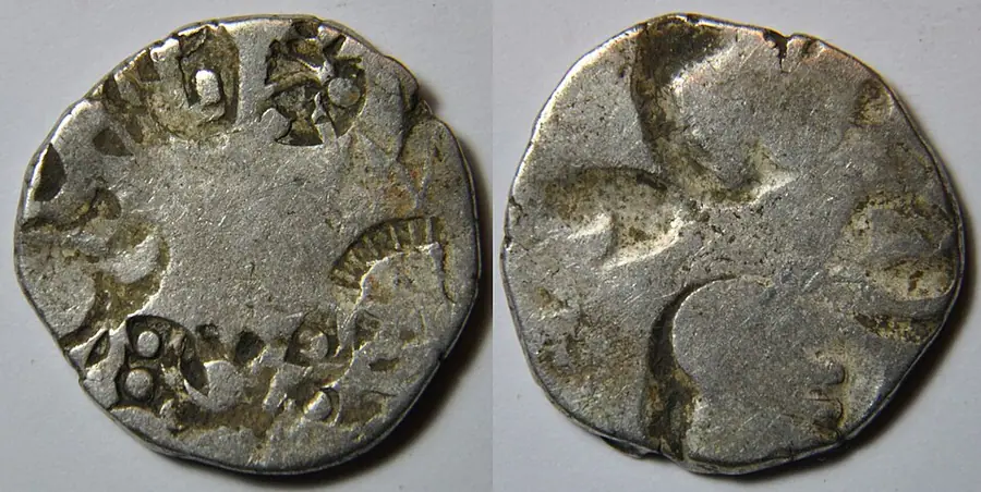 Both faces of a worn silver punch-marked coin of Magadha, stamped with a sun, a six-armed symbol and other marks