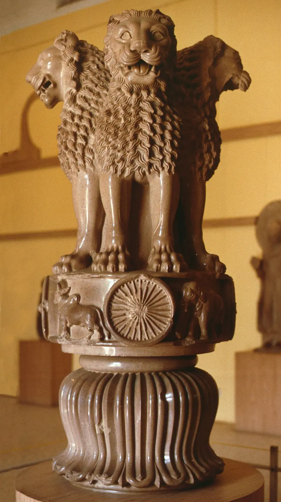 The Lion Capital of Ashoka from Sarnath: four back-to-back lions above a wheel, in a museum