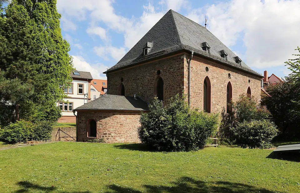 The Romanesque synagogue of Worms seen from its garden side: a stone hall with round-arched windows, rebuilt after 1945 on medieval foundations